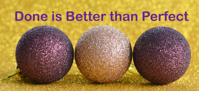 Three purple decorative holiday balls sit in a row with the words done is better than perfect on a gold sparkle table